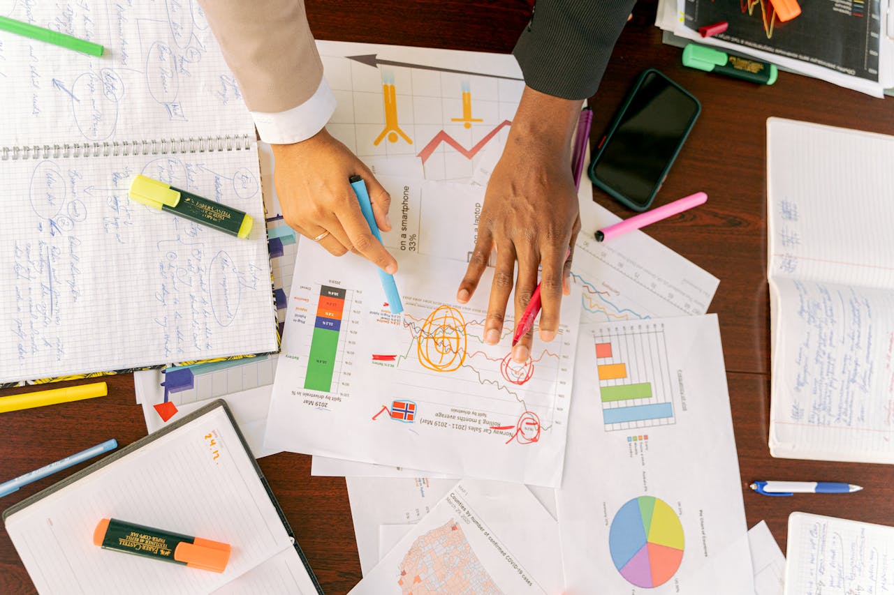Top view of diverse professionals analyzing business data with charts.